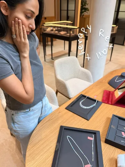 The joy of finding the perfect piece. Here, a client is admiring diamond necklaces during a jewelry consultation, an essential part of completing the bridal look.