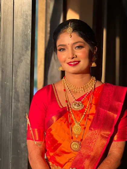A happy and bright portrait of Raksha, her red lipstick perfectly matching her beautiful saree.