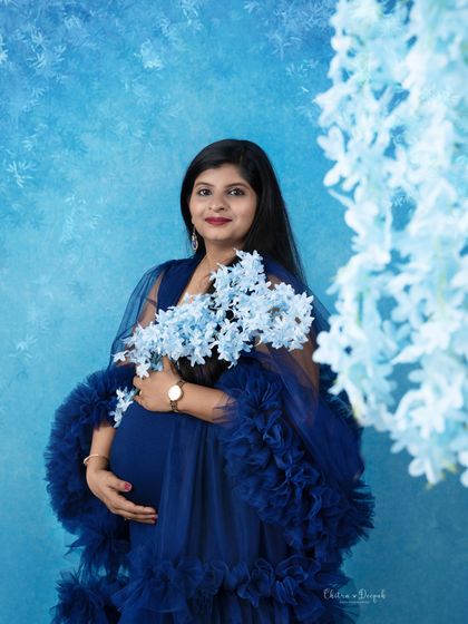A winter wonderland feel with shades of blue. This mom-to-be holds a bouquet of blue flowers that perfectly match her elegant ruffled gown.