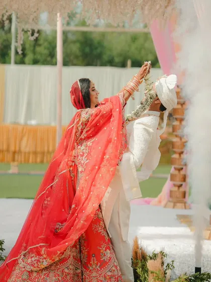 A dynamic shot of the varmala exchange, with smoke effects adding a touch of drama and magic to the moment.