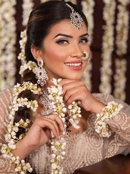 This bride's look features a long, decorated braid with fresh flowers, a popular choice for traditional Indian weddings that I teach in my hairstyling modules.