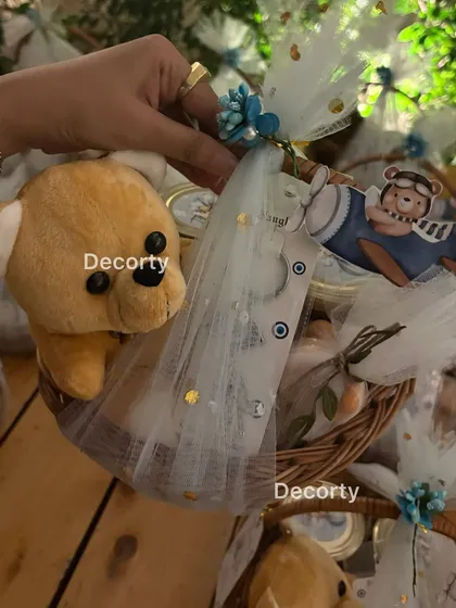 A close-up of the adorable return gift baskets for the Aviator Bear party. Each basket includes a small teddy bear and other themed goodies, beautifully wrapped in tulle.