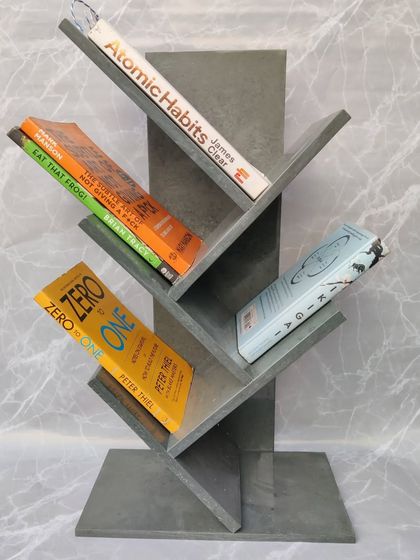 The grey marble bookshelf, styled with a collection of inspiring books. Each shelf is angled to create a dynamic and eye-catching display for your reading collection.