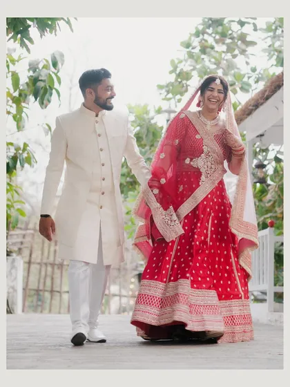 A joyful, candid shot of the couple walking and laughing together, capturing the pure happiness of their wedding day.