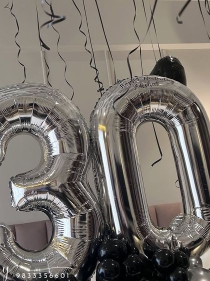 A close-up of the large '30' silver foil balloons. We can add custom vinyl text, like a name or 'Happy Birthday', directly onto the foil balloons for a personal touch.