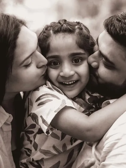 A beautiful black and white portrait showing a daughter showered with love from both her parents. This timeless image focuses purely on the emotion and connection within the family.