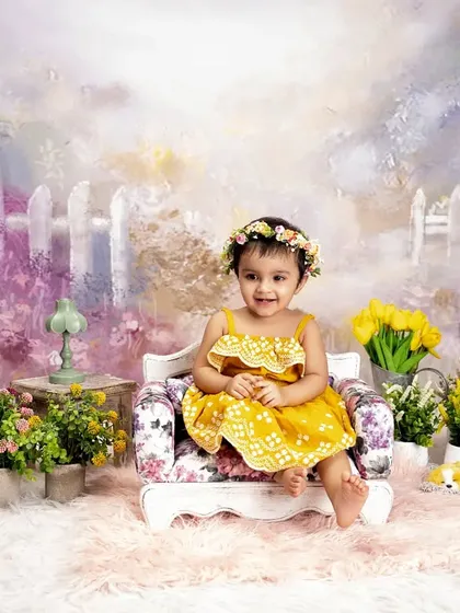 A happy moment in a field of flowers. This cheerful portrait captures a beautiful smile amidst a soft, pastel-colored garden backdrop, creating a light and airy feel.