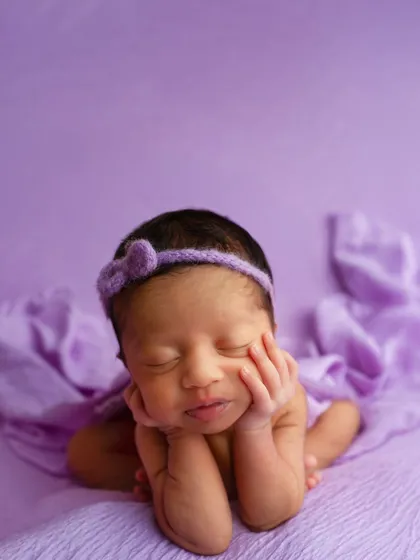 The final result of a 'froggy pose', where the baby appears to be resting their chin on their hands. This is a composite image created with full support for the baby at all times.