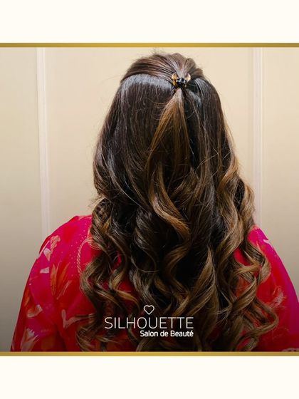 Reimagine your hair with the art of bespoke colour. This style showcases soft curls enhanced with subtle highlights, creating a look that is both natural and refined.