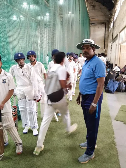 A coach watches over the U-19 aspirants as they go through their paces in the indoor nets.