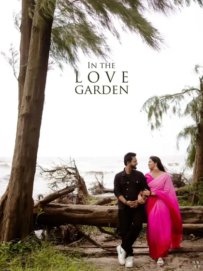 "In the Love Garden." This branded image perfectly frames the couple against the backdrop of the sea and trees, capturing the essence of their romantic escape.