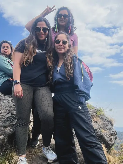 A joyful moment captured at the top of a mountain peak during a sunrise hike. Our guided treks are designed to be both challenging and rewarding, offering stunning views and a sense of accomplishment.