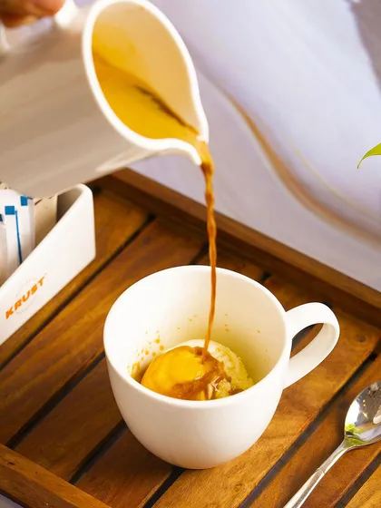 A shot of our Affogato being prepared, with a rich espresso shot poured over a scoop of creamy ice cream. It's a simple yet incredibly satisfying coffee dessert.