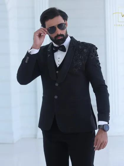 A close-up of the model wearing our black embroidered tuxedo. The fit across the shoulders and chest is a testament to our precise custom tailoring process.
