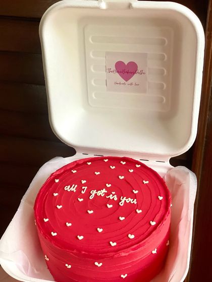 A bold red bento cake for Valentine's Day with the message 'all I got is you' surrounded by white hearts. A sweet way to show someone they're your everything.