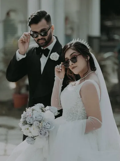 The bride and groom add a touch of modern cool with sunglasses, a fun and stylish take on the classic wedding portrait.