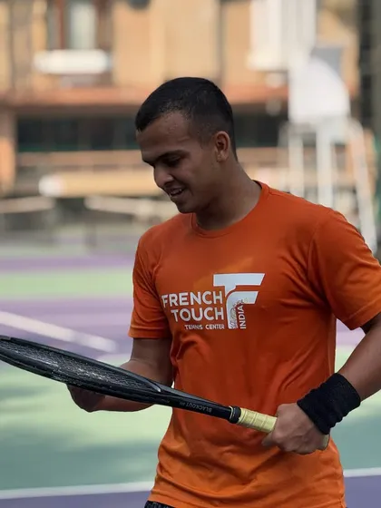 A moment of focus between points. A player wearing our French Touch India shirt inspects his racquet, showing the mental preparation and attention to detail we encourage.