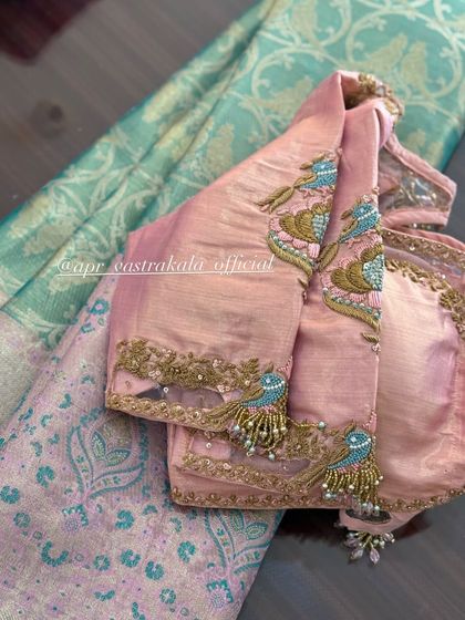 A pink blouse with embroidered bird motifs on the sleeves and a simple back.