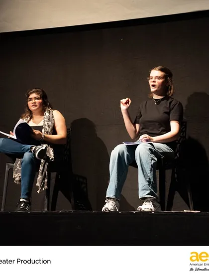 Students engage in a dialogue during a scene from a high school production. The collaborative nature of theatre teaches invaluable lessons in teamwork, listening, and mutual respect.