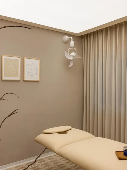 The treatment room in this wellness center is a study in minimalist tranquility. We used a monochromatic color scheme, sheer floor-to-ceiling curtains for soft, diffused light, and natural elements like the bare branches to create a pure and uncluttered sanctuary for relaxation.