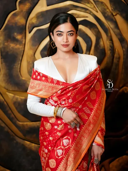 A striking portrait of actress Rashmika Mandanna for an Anandalok magazine shoot. The modern styling with a traditional red Banarasi saree creates a unique fusion look, highlighting my approach to contemporary ethnic fashion.