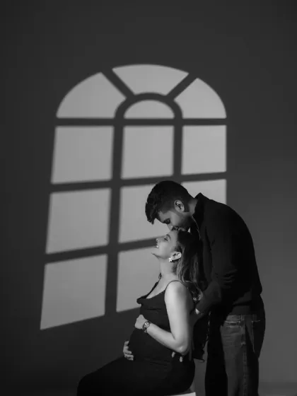I often use shadows to add depth and emotion. Here, the shadow of a window frame suggests a home, a future, and the new life about to begin, all while keeping the focus on the couple's quiet, intimate connection.
