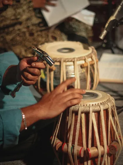 A close-up of the tabla and the tuning hammer. Keeping the drums perfectly tuned is a crucial part of the art, ensuring the sound is precise and resonant throughout a performance.