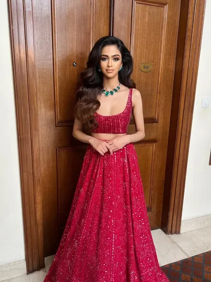 The same red lehenga, showing its versatility and timeless appeal in a different setting.