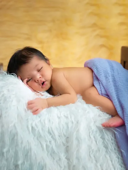 From their little fingers to their tiny toes, we make sure to capture all the details you'll want to remember. This pose highlights the baby's delicate features in a studio setting.