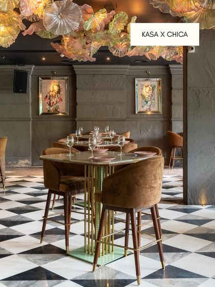 At the restaurant Chica, I used a classic black and white checkerboard marble tile for the floor. This timeless choice provides a bold graphic foundation that contrasts beautifully with the opulent, colorful decor, including the stunning glass chandelier.