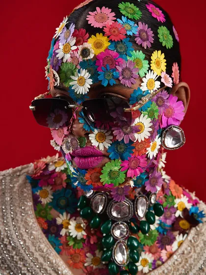 A truly avant-garde bridal concept, where a student has turned the model into a "flower head" masterpiece, covering her face in a mosaic of colorful flowers.
