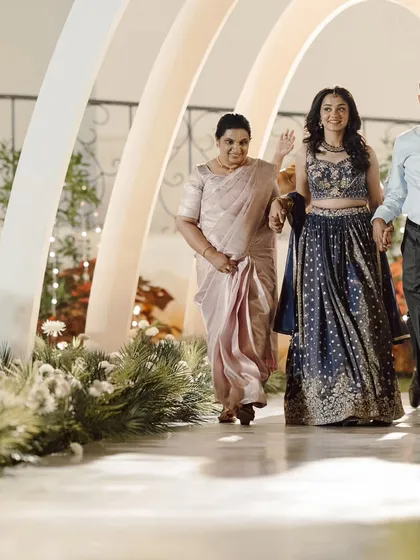The bride's grand entrance at her Roce ceremony. She walks through a stunning tunnel of modern white arches, a contemporary and elegant design that made the moment truly special.