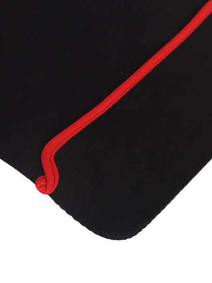 A close-up detail shot of the corner of a black and red laptop sleeve, showing the stitching and fabric.