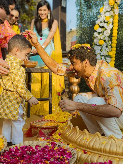 A groom shares a playful moment with a young family member during his Haldi ceremony. These interactions add a sweet, personal touch to the wedding album.