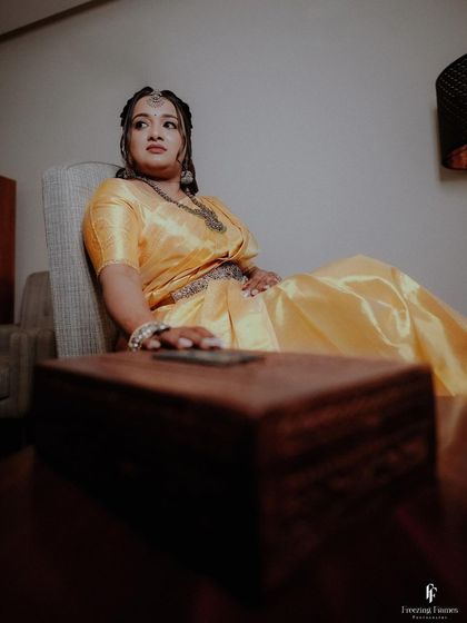 A portrait of the bride in her yellow engagement saree, capturing her regal and composed look.