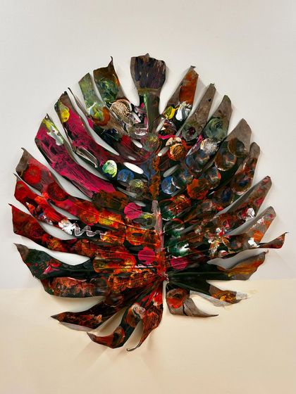 The finished community-painted leaf, a testament to the beauty of process art. Each mark, color, and pattern tells a story of a different person's contribution, creating a whole that is greater than the sum of its parts.