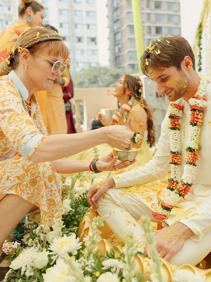 A guest lovingly applies haldi to the groom. It's these moments of connection and blessing between families that make the ceremony so meaningful.