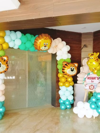 A welcoming entrance for a jungle-themed first birthday party. This balloon arch with friendly animal faces is a great way to greet guests and set the tone for the celebration.