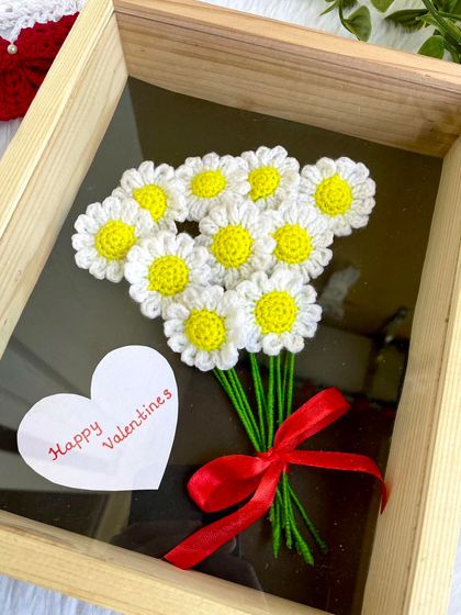 A cheerful bunch of crochet daisies in a wooden shadow box frame. This piece is perfect for Valentine's Day or any day you want to send a message of happiness.