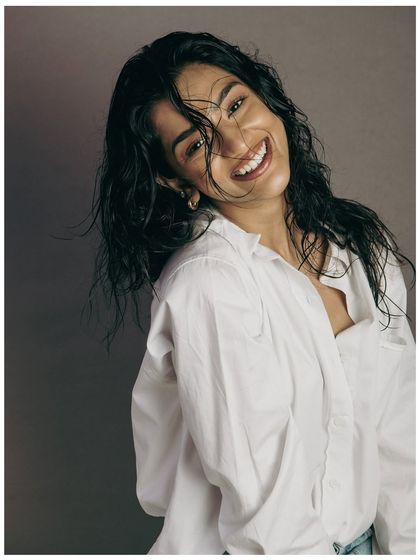 A joyful, candid moment that still highlights the hair. The model's laugh and head tilt create natural movement, showing how the hairstyle looks in action. It adds a touch of personality to the series.