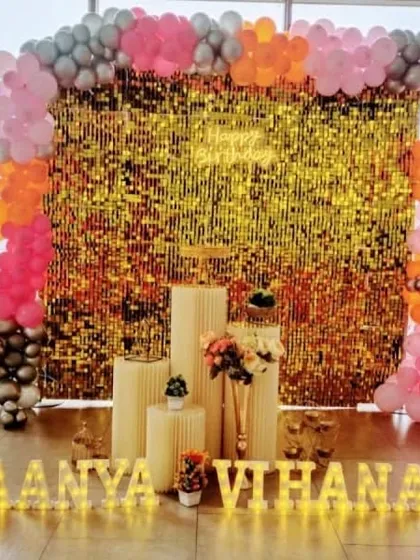 A duplicate of image 138, showing a gold sequin wall with a colorful balloon garland.