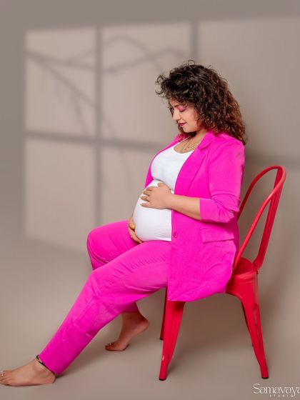 A contemplative seated portrait, with a window-like shadow adding depth and mood. This is an example of creative lighting in a minimalist setting.