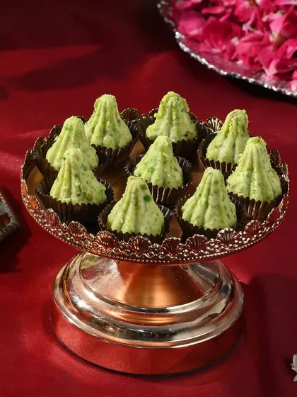 A beautiful serving of my pistachio-flavoured modaks on a copper-finish pedestal stand. The presentation is just as important as the taste.