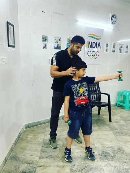 Physical conditioning is a vital part of shooting. Here, I am guiding a young athlete through strength training exercises designed to improve stability and endurance for holding the pistol.