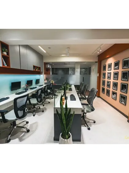 A view of our main workstation area, designed for collaboration and focus. The long desk is complemented by ergonomic chairs and a gallery wall of our proudest project moments.
