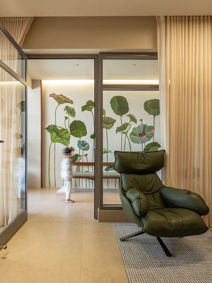 This view shows the connection between the living area and a semi-private study, separated by glass doors. A beautiful lotus-themed wall mural adds a unique, artistic touch to the space.