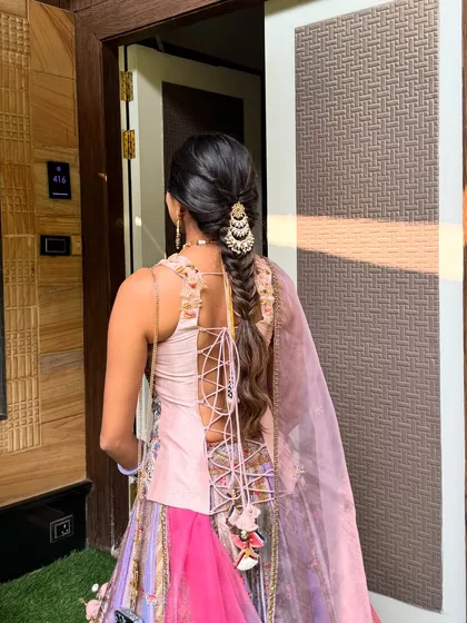 A full view of a fishtail paranda braid, showing how it complements the entire outfit. This style is perfect for keeping long hair beautifully managed throughout a busy wedding function.