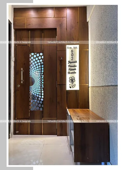 Another view of the entrance for the 1BHK apartment, showing the custom-lit nameplate and the integrated shoe rack with a bench. Every element is designed to be both beautiful and useful.