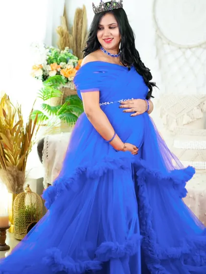 A bold and beautiful statement in royal blue. This ruffled gown fills the frame, with the mom-to-be looking like royalty in our boho-chic studio setting.