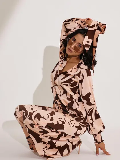 A full-length printed co-ord set styled with retro-inspired sunglasses. The crouching pose adds a dynamic, editorial feel to this e-commerce or lookbook shot.